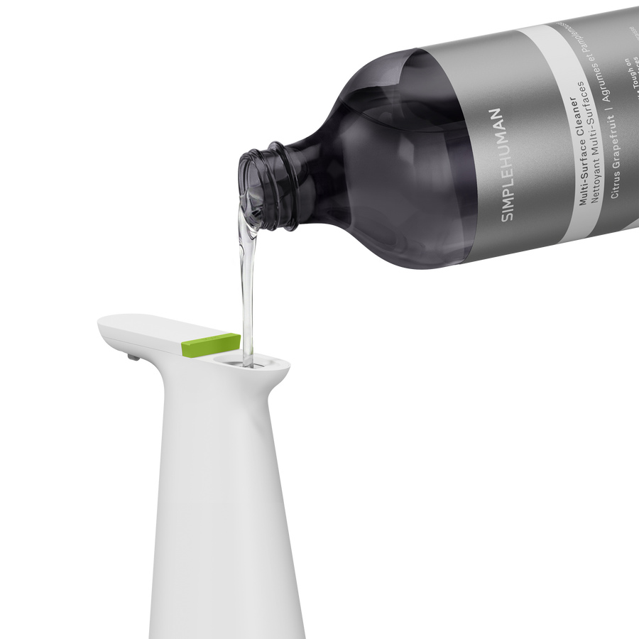 Simplehuman's Sensor Spray in White with Multi-Surface Cleaning Refill Bottle pouring into the spout. 